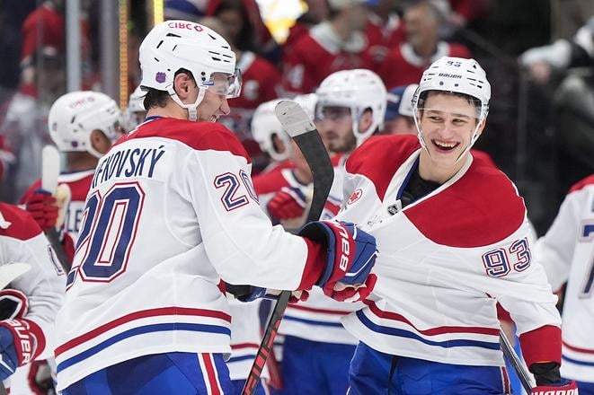 Na snímke slovenský hráč Montrealu Juraj Slafkovský (v popredí vľavo) a jeho spoluhráč Ivan Demidov sa radujú po výhre v zápase zámorskej NHL Vancouver - Montrea.