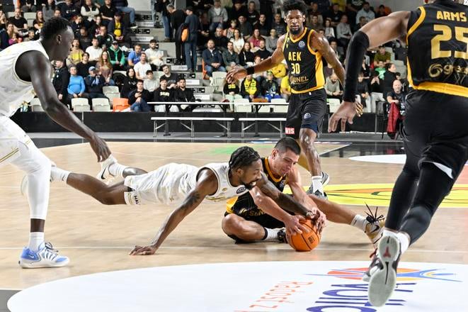 Rickey McGill, v bielom drese Levíc, bojuje o loptu s hosťujúcim Dimitrisom Flionisom.