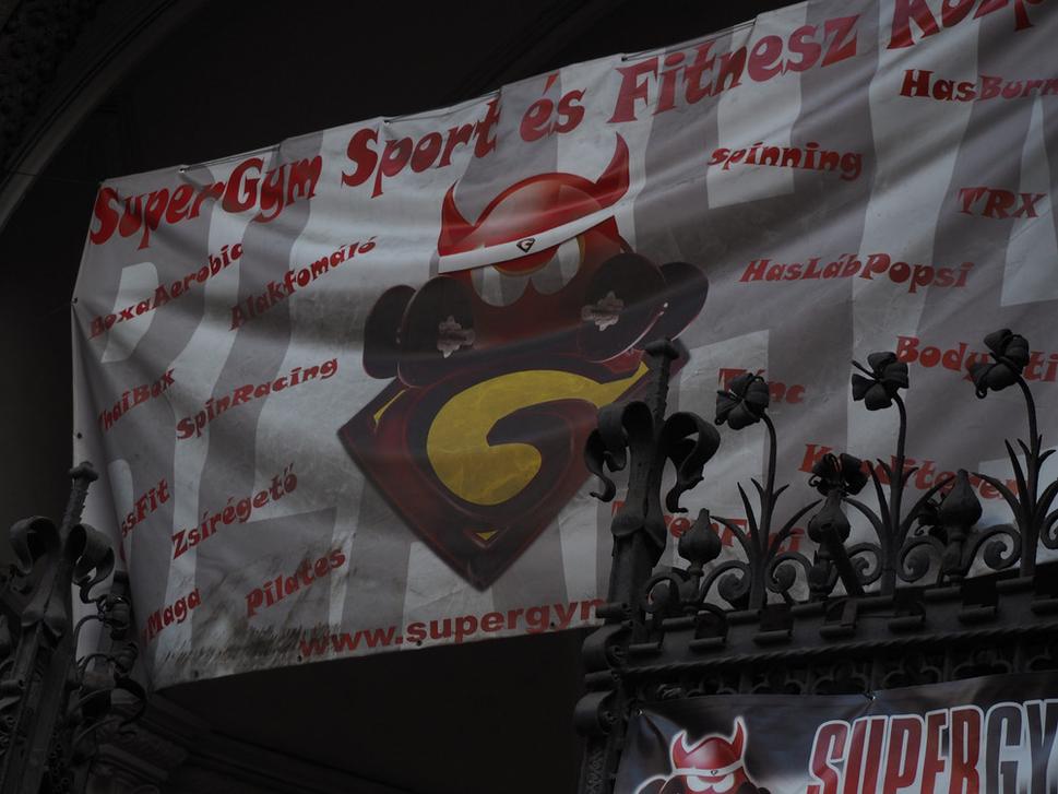 Logo fitnescentra nad železnou bránou