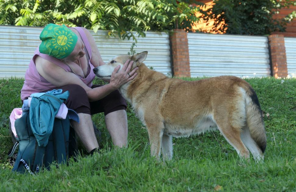 Pani Galina z Moskvy kŕmi pri jazere psíka