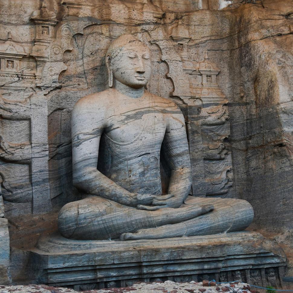 Sediaci a ležiaci Budha zdobiaci chrám Gar Vihara sú vytesaní priamo zo skaly na priečelí.