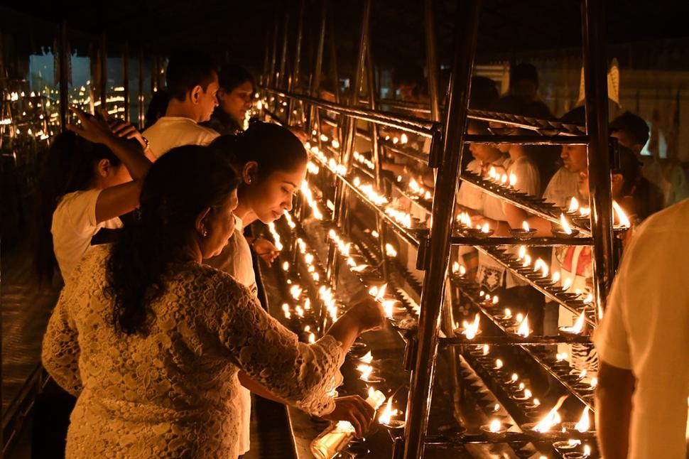Veriaci zapaľujú pred chrámom Budhovho zubu sviečky. Umocňuje to atmosféru tohoto najposvätnejšieho budhistického svätostánku na celej Sri Lanke.