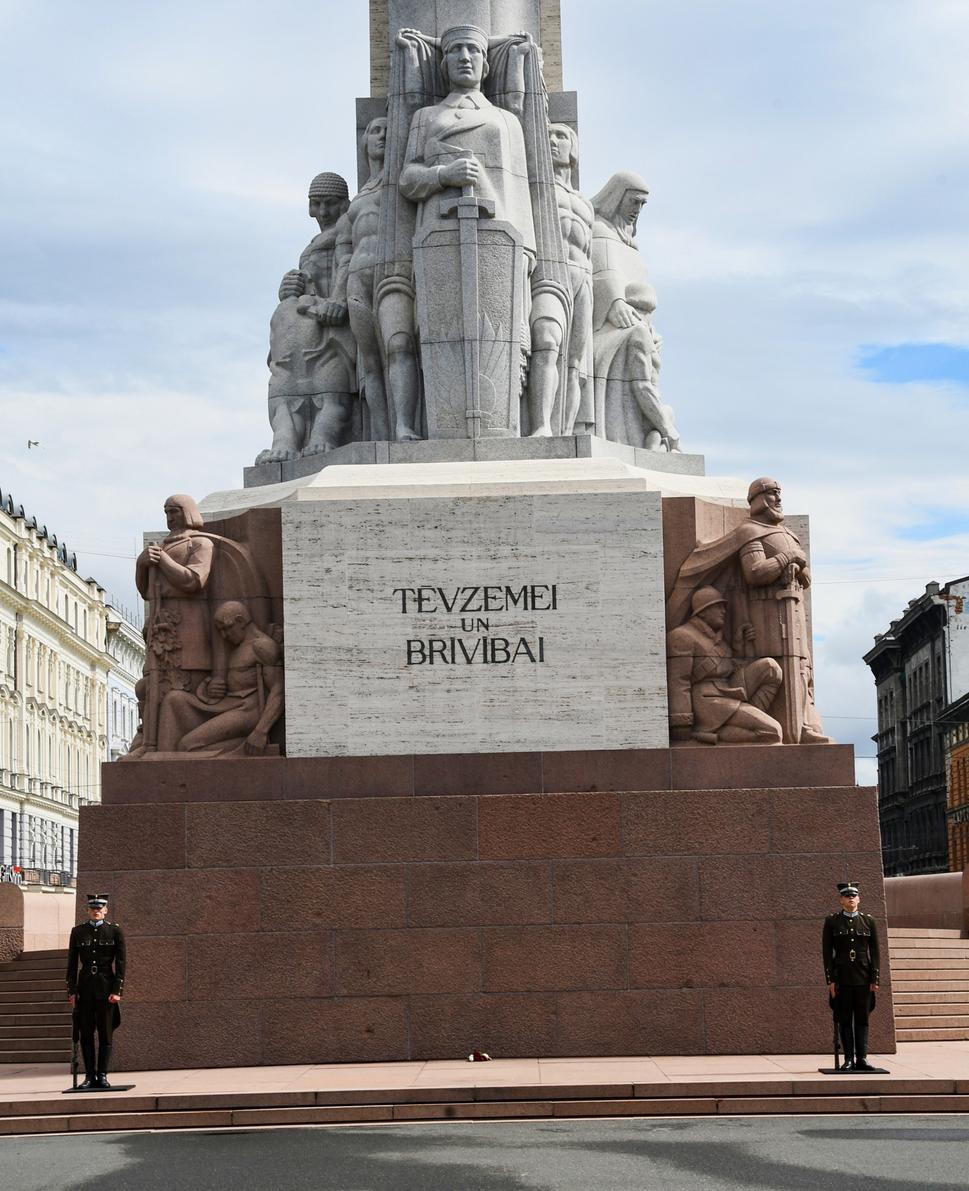 Tevzemei un Brivibai - "Za vlasť a Slobodu". Pri päte pomníka stojí niekoľko sôch, ktoré reprezentujú hodnoty ako je práca, rodina, sila národa, sila viery, a historický odkaz. Čestná stráž sa mení každú hodinu.