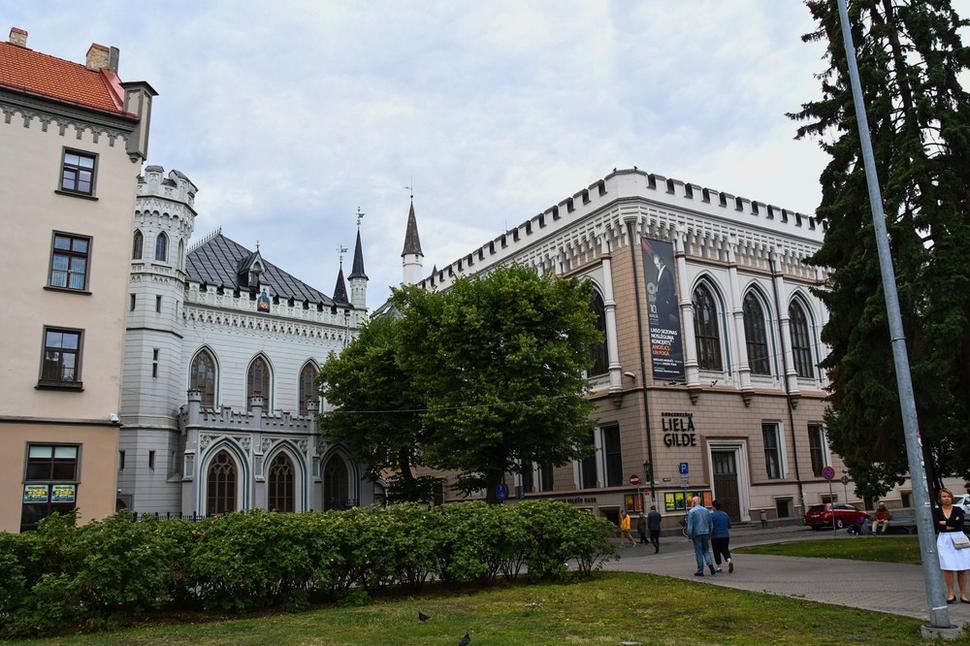 Oproti Mačaciemu domu sídlila v menšej budove vľavo Malá gilda. Veľkej gilde patrila väčšia budova vpravo.