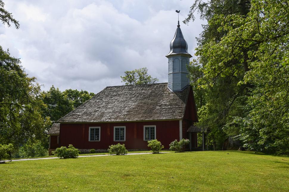 Po vstupe do rezervácie, na ceste k hradu prechádzame vedľa jedného z najstarších lotyšských kostolov. Drevený luteránsky kostol bol postavený v roku 1750 na mieste dvoch starších kostolov. Radí sa k najkrajším ukážkam lotyšskej ľudovej architektúry.