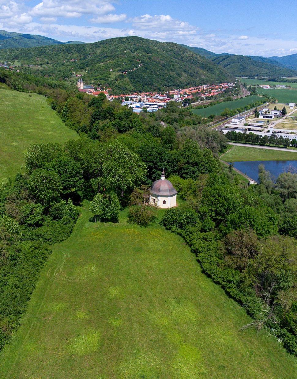 Pohľad na severnú časť hradiska s Morovou kaplnkou Božej krvi z juhu. V pozadí je Hronský Beňadik a veže kláštora.