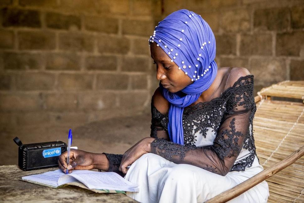 Aichata (15) počúva učivo cez rádio nabíjané solárnou energiou v regióne Ségou, Mali.