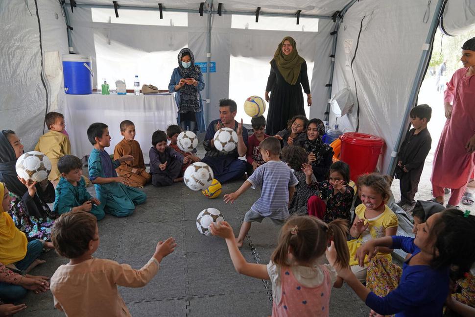 Deti sa zúčastňujú voľnočasovej aktivity v priestore vytvorenom UNICEFom na strednej škole Peer Mohammad Kakar, v ktorej je ubytovaných viac ako 400 rodín po úteku z ich domovov pred konfliktom. Od začiatku roka 2021 bolo v Afganistane vnútorne vysídlených viac ako 390,000 ľudí, z toho viac ako polovica detí. Kábul, 14. august 2021.