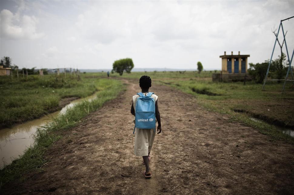 Dievča s batohom UNICEF kráča domov z vyučovania v dedine Gogbo v Benine. UNICEF bol prítomný v Benine po silných záplavách a zabezpečoval prístup k pitnej vode, toaletám a obnovu vodných zdrojov po prírodnej katastrofe.