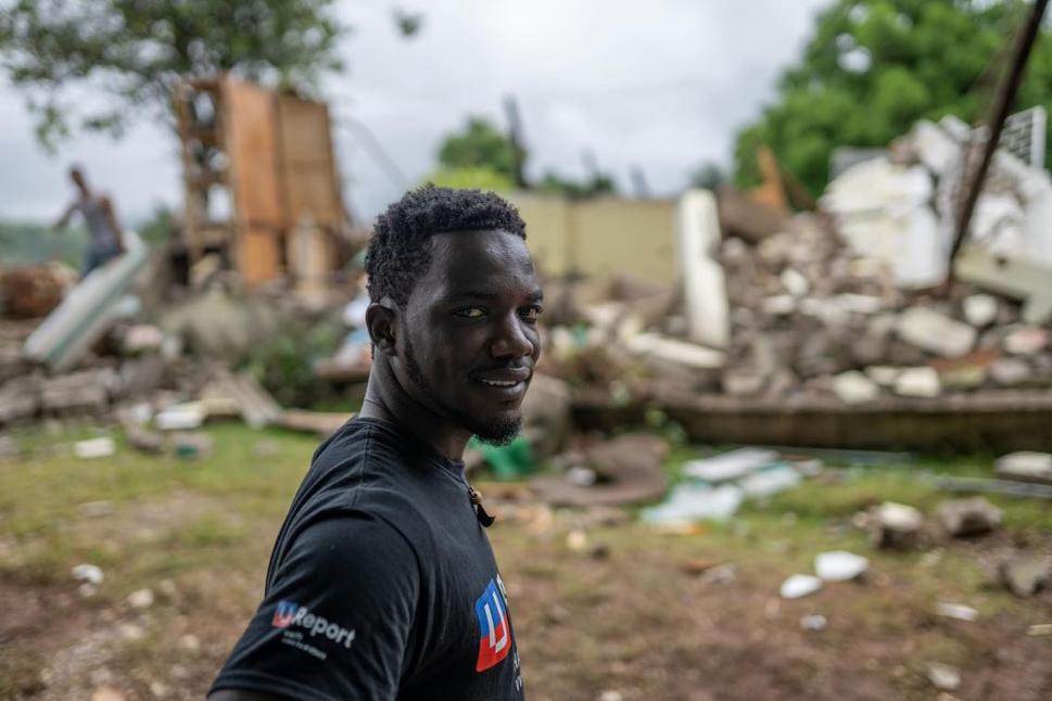 Wadelet stojí pred zrútenou budovou v Pestel, Haiti