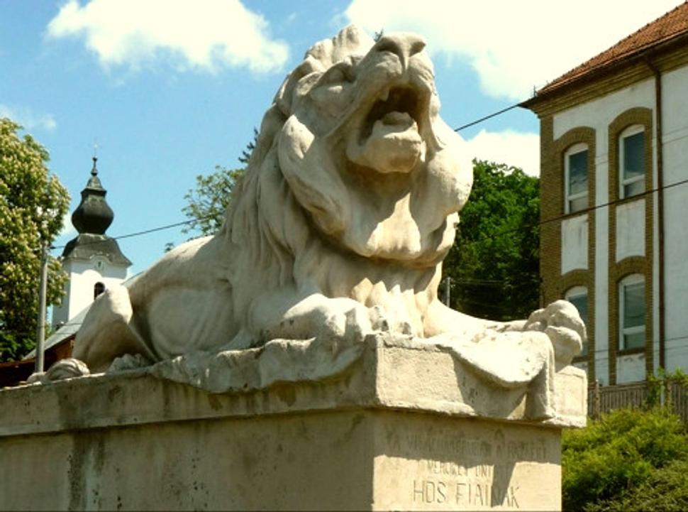Giraltovský lev si vylihuje nejaký ten rok pred budovou bývalého okresného súdu, v pozadí vidno vežu evanjelického kostola