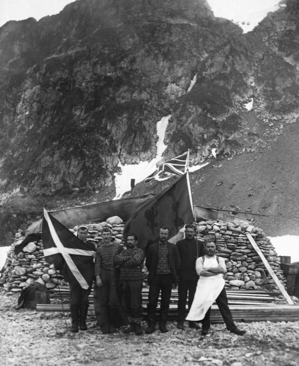Prezimujúca skupina pred Omond House počas antarktického leta vo februári 1904. Zľava: A. Ross -vedecký asistent, W. Cuthbertson - maliar, J.H.H. Pirie - geológ a chirurg, W. Martin - námorník a vedecký asistent, R. Mossman -meteorológ, W. Smith - kuchár
