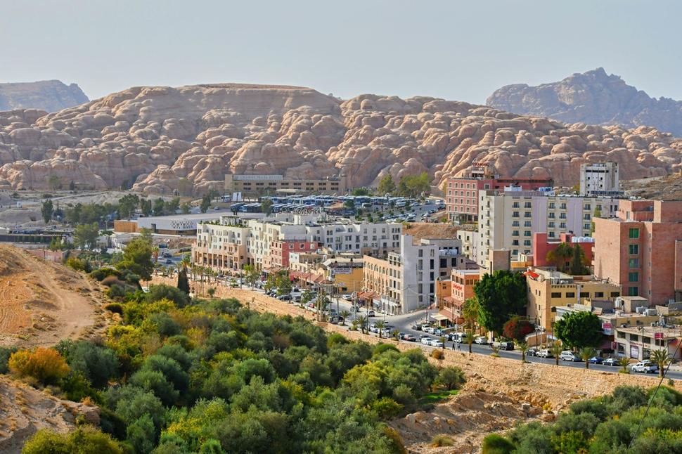 Mesto Wadi Musa. Turistické centrum, cez ktoré sa vstupuje do údolia a rokliny Siq, je na ľavej strane obrázku. Petra je ukrytá v srdci skalných hôr, tam v diaľke za obzorom.