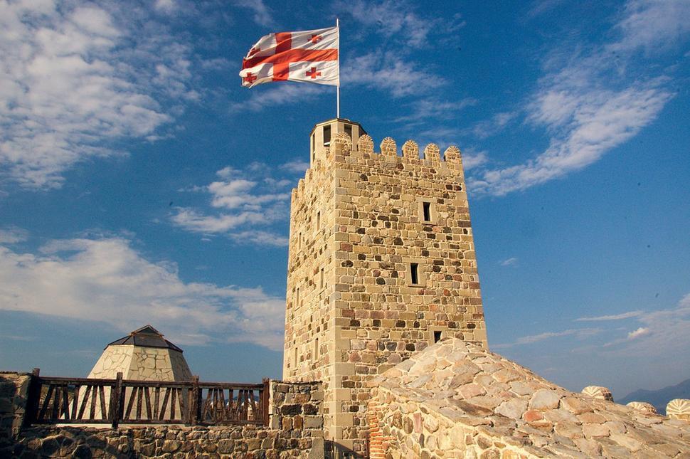 Veža v pevnosti Rabat v Achalciche. Vo vetre nad ňou sa trepoce veľká gruzínska vlajka. Je tvorená červeným sväto-jurajským krížom a štyrmi menšími krížmi v uhloch. Bola prijatá 14. januára 2004 po „revolúcii“ ruží“ a nástupe prezidenta Saakašviliho.