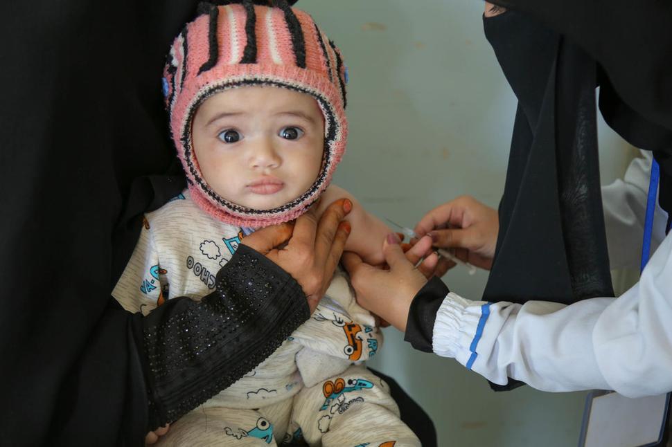 Dieťatko počas očkovacej kampane UNICEFu proti osýpkam a rubeole v Jemene. Táto vakcína za posledných 20 rokov každoročne zachránila viac ako jeden milión životov.
