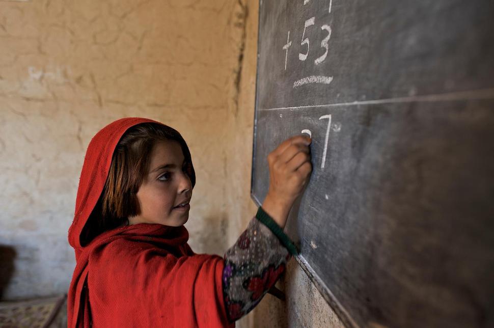 Študentka pri riešení príkladu vo vzdelávacom centre UNICEF v Pakistane. Obyvatelia sú tu vystavení dlhotrvajúcim ozbrojeným konfliktom medzi lokálnymi skupinami a krajina je v posledných rokoch navyše postihnutá najhoršími záplavami v histórii. Mnoho ľudí muselo opustiť svoje domovy a UNICEF pre nich vo vysťahovaleckých táboroch zabezpečuje prístup k pitnej vode, liečbu podvýživy, prístrešie a základné očkovanie.