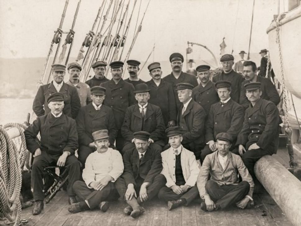 Posádka lode Fram po vyplávaní z nórskeho prístavu v Bergen. Amundsen sedí v strede fotografie.