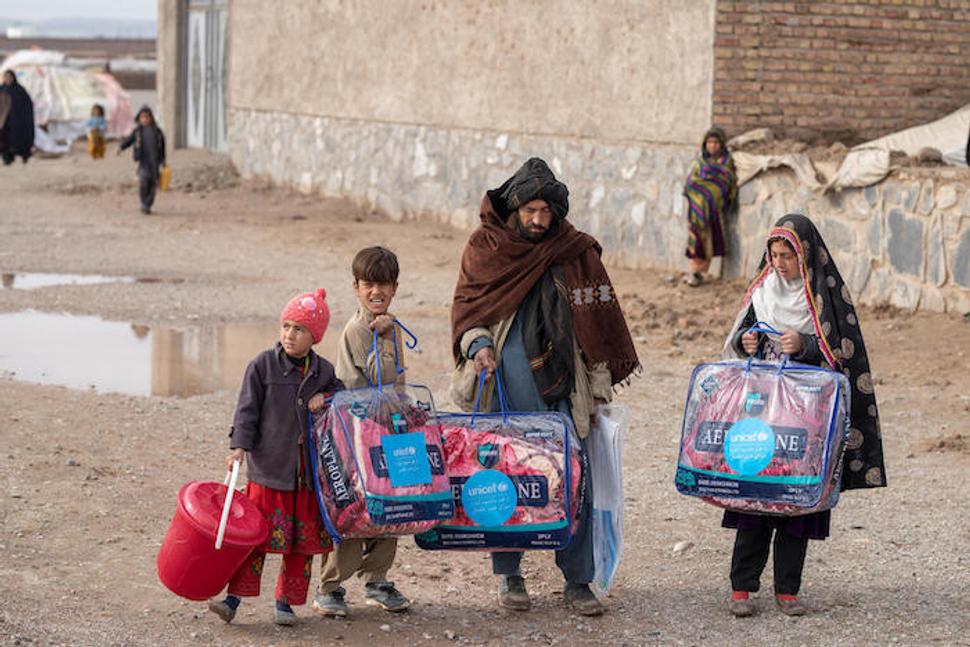 Juma Gul, 32 a jeho rodina si odnášajú teplé prikrývky a zimné oblečenie distribuované UNICEFom, ktoré im pomôžu prečkať tuhú afgánsku zimu.
