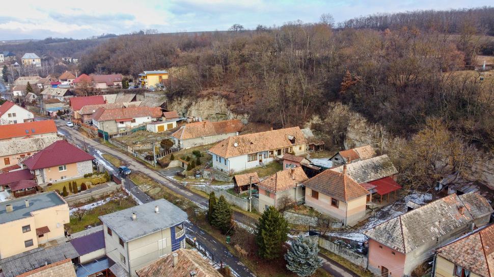 Pohľad na ulicu so skalnou stenou, vedúcu zo stredu dediny do dolín Sulovrieš a Halôš a ďalej povedľa potoka Búr do obce Bory.