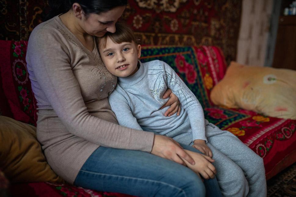 Polina, 7, z východnej Ukrajiny v náručí svojej mamy. Polina utrpela zranenia pri výbuchu míny pred ich domom počas ozbrojeného konfliktu. Jej stará mama zahynula a rodičia boli tiež ťažko zranení. UNICEF poskytuje psychosociálnu pomoc ľuďom, ktorí utrpeli zranenia alebo prišli o svojich blízkych následkom výbuchu mín alebo inej munície v prebiehajúcom konflikte na Ukrajine.