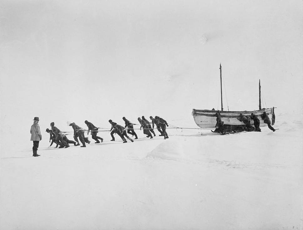 Posádka lode Endurance ťahá po jej stroskotaní naložený čln po ľadovej kryhe.