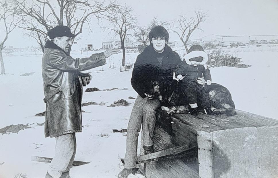 Naša roľa, vedľa ulice Za humnami, v pozadí vidno družstvo. Dedo, otec, ja a vlčiak Žufo. Rok 1984.