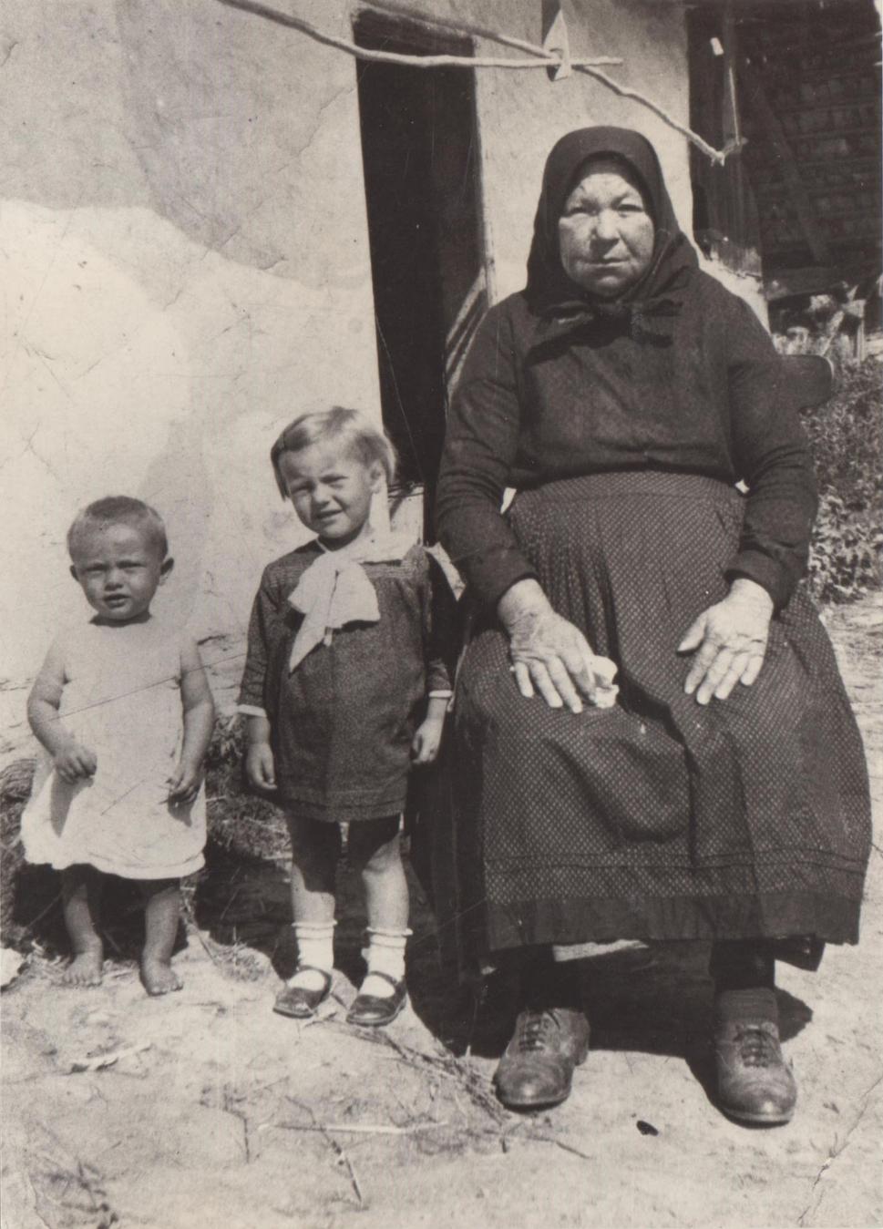 Štefan Ihnat vľavo na fotografii so svojou sestrou Zuzanou a babičkou pred domom v Jastrabí pri Michalovciach.