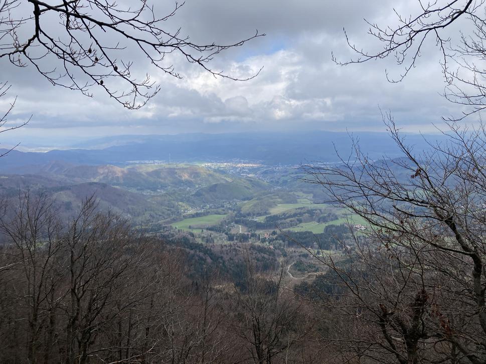 Pohľad na Kordíky zo sedla, v pozadí Banská Bystrica, nad ňou Strohorské vrchy a Nízke Tatry