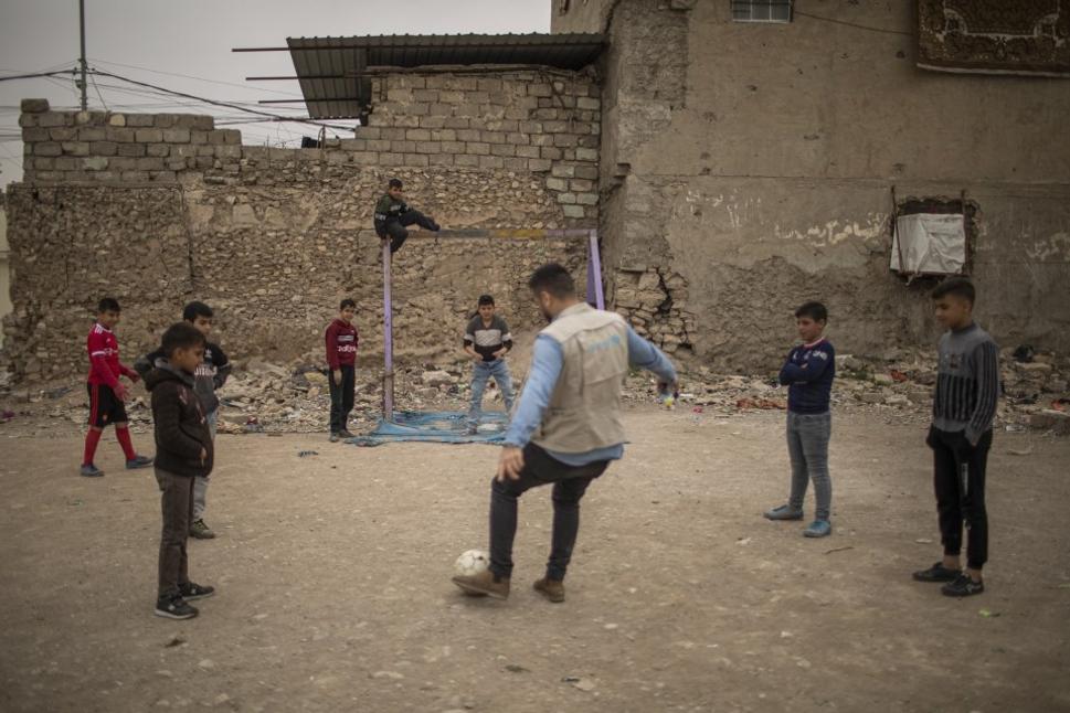 Člen UNICEF tímu hrá futbal s deťmi v uliciach Starého mesta Mosulu.