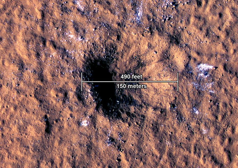 Na snímku z kamery HiRISE sondy MRO (Mars Reconnaissance Orbiter) vidíme veľké kusy balvanov, ktoré sú v podstate kusmi ľadu. Samotný kráter vznikol 24.12.2021 dopadom meteoroidu v oblasti Amazonis Planitia na Marse.