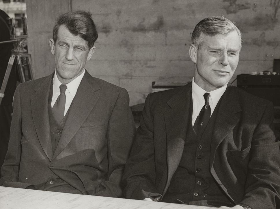 Zľava Edmund Hillary a Vivian Fuchs počas tlačovej konferencie vo Wellingtone po návrate z Trans-Antarktickej expedície, 1958. Podľa toho, ako sa tvária, sa zdá, že sa Fuchs nezmieril s Hillaryho 3. miestom v dosiahnutí južného pólu, ktoré chcel pre seba.