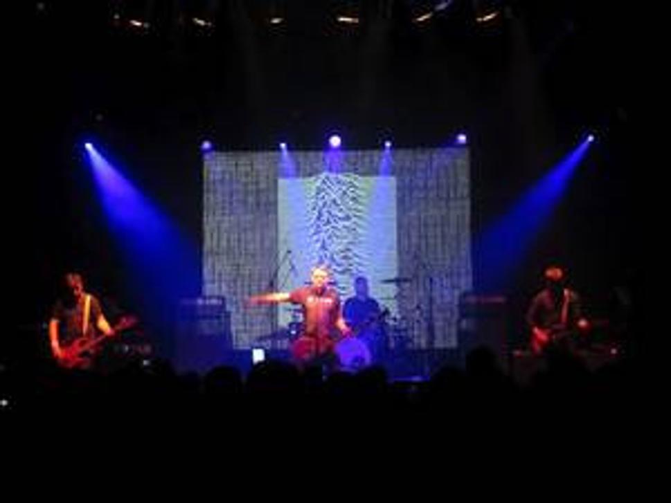 Joy Division v podaní Peter Hook, v pozadí obal albumu spred 30 rokov