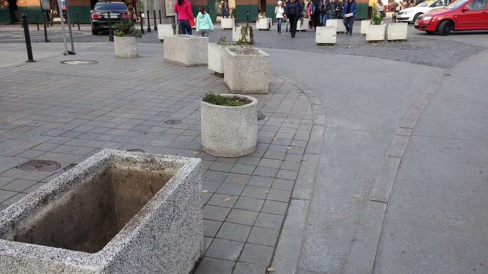 Magistrátne kvetináče pri Hviezdoslavovom námestí. Rôzne typy špinavých kvetináčov bez "obsahu". Potešenie pre turistov v pozadí.