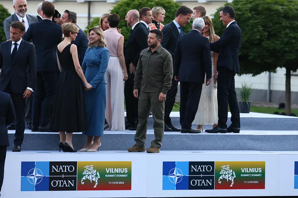 Fotka, z ktorej mrazí. Prezident Volodimir Zelenskyj, ktorého krajina čelí Ruskej agresii, na samite NATO vo Vilniuse, po oficiálnom príhovore a fotení. Sám s vojenskými balíčkami pomoci.