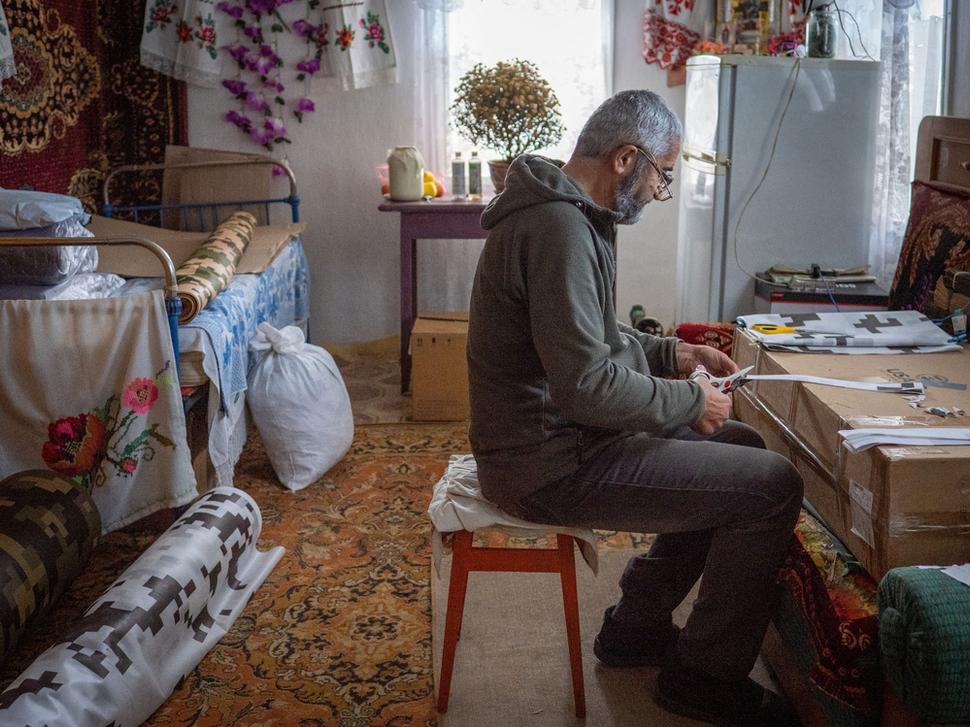 Irinin manžel Vladimír strihá materiál na výrobu sietí