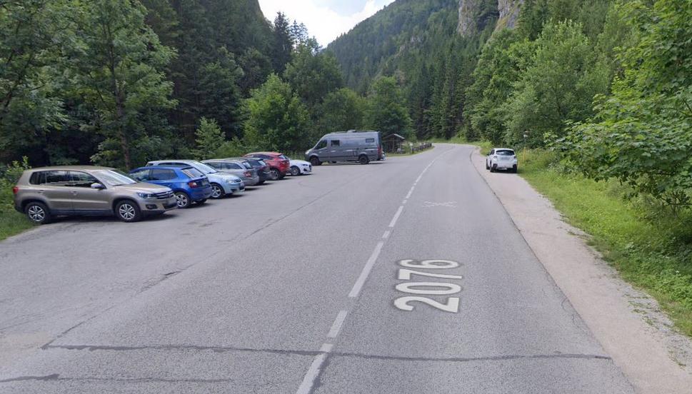 Parking a okolo toho vpravo odparkovaného hulváta, po značke hore.