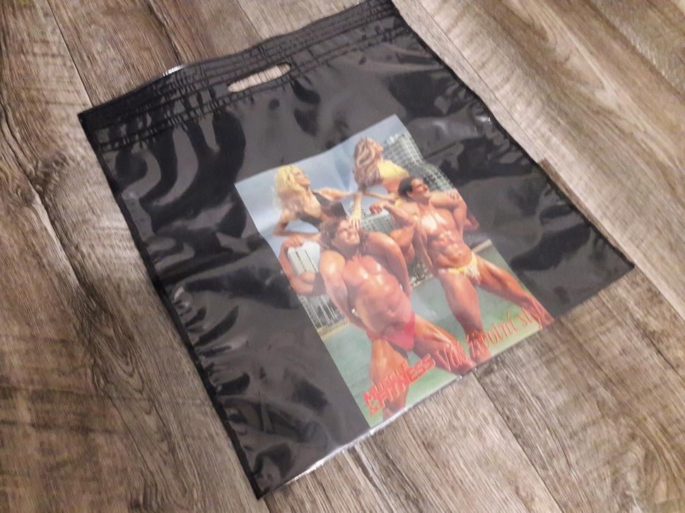 Originálna igelitka z roku 1990
Čierna taška s kultovým dizajnom „Muscle & Fitness – Váš životní štýl“ je autentický kúsok z prelomu 80. a 90. rokov. Žiadna replika, žiadny vintage obchod. Táto igelitka prežila dekády v sklade a dnes stále slúži. Náhodný nákup v malom obchode sa tak premenil na výlet do minulosti.