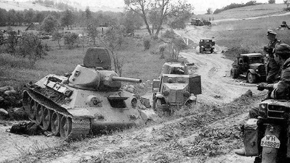 Nemeckí vojaci si prezerajú zničenú sovietsku techniku v čele s tankom T-34. Neďaleka mesta Dubno, jún 1941