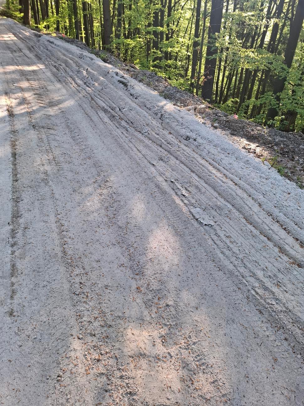 Piesok, ktorý tvorí posledné podlažie cesty je len uvalcovaný. ( foto ešte pred zavalcovaním) Piesok začne pomerne rýchlo zmývať dážď a to aj napriek vyhĺbeným kanálom.