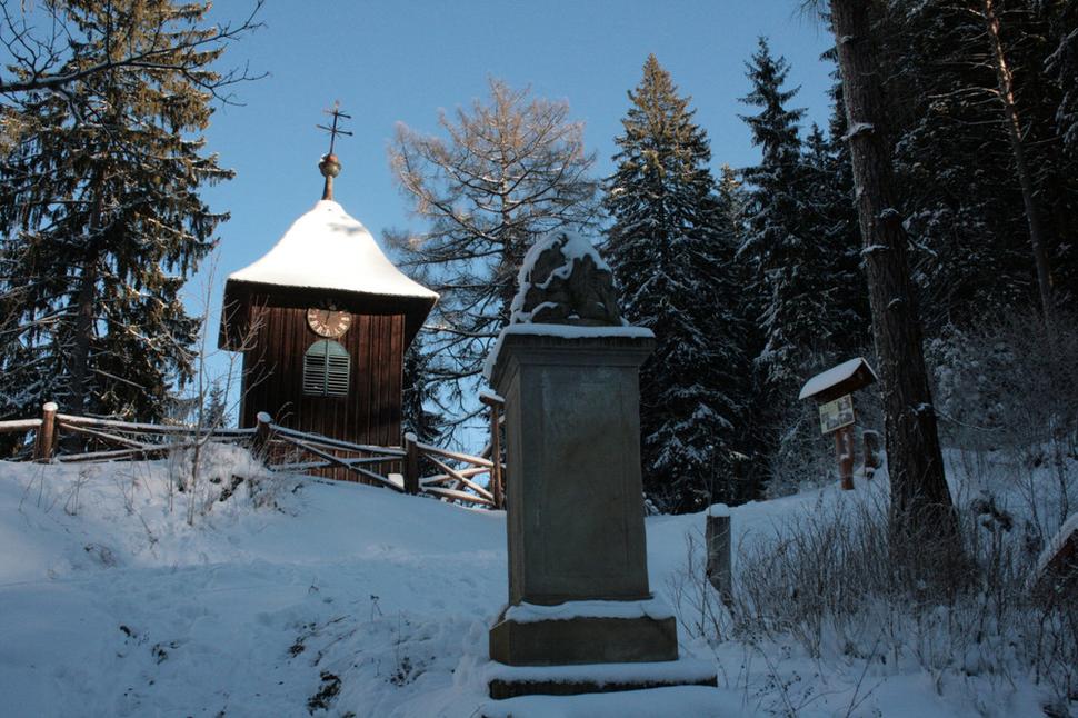 Drevená zvonička, v popredí pieskovcový monument, pripomínajúci, že 29. augusta 1804 v týchto revíroch poľoval korunný princ, vnuk cisárovnej Márie Terézie a brat cisára Františka I., arciknieža Jozef Habsburský, palatín Uhorska v rokoch 1796 až 1847.