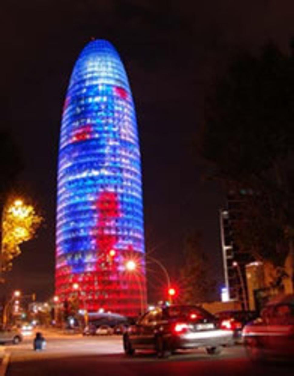 Torre Agbar v noci svieti do dialky.
