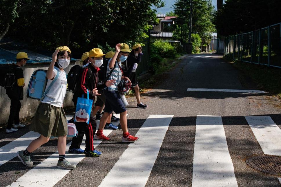 Skupinka školákov prechádza cez cestu v Tochigi prefektúre, Japonsko.