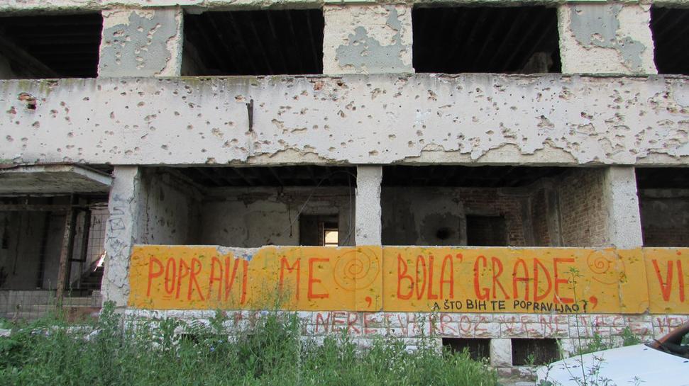 „Oprav ma, ubolené mesto.” Nápis na zničenej budove v Mostare.