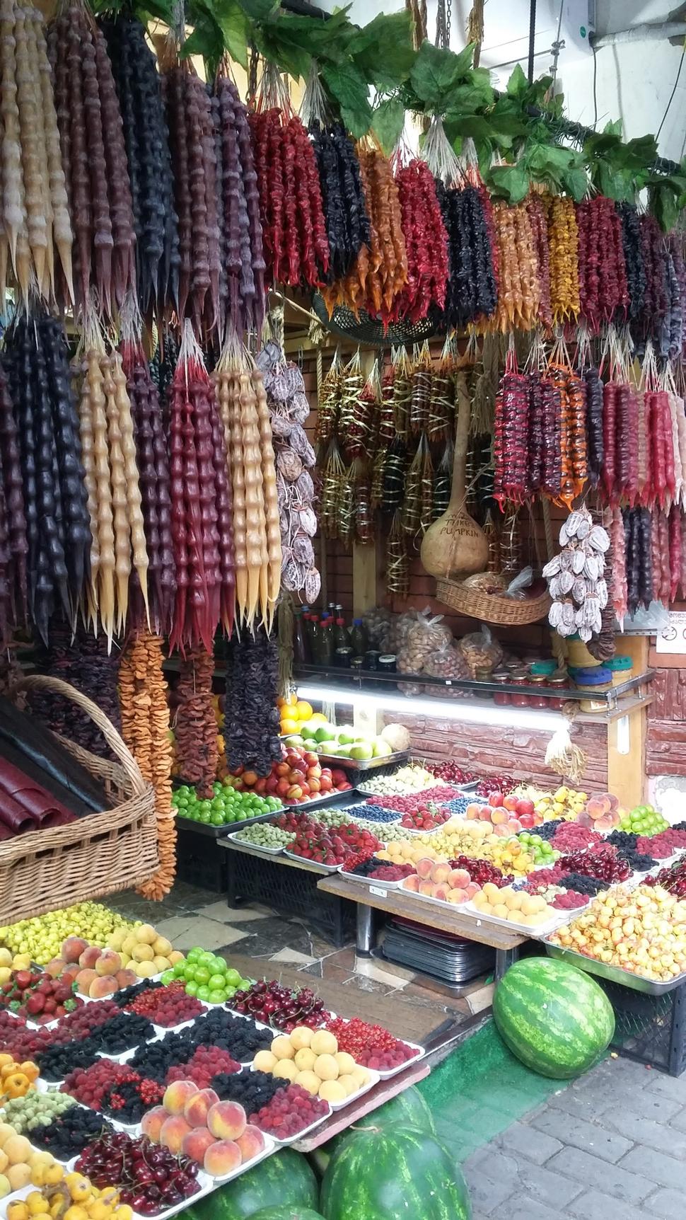stánok s ovocím a pochutinami (tie farebné veci čo visia sa volajú čurčchela, je to pochúťka z ovocia, múky a orechov)