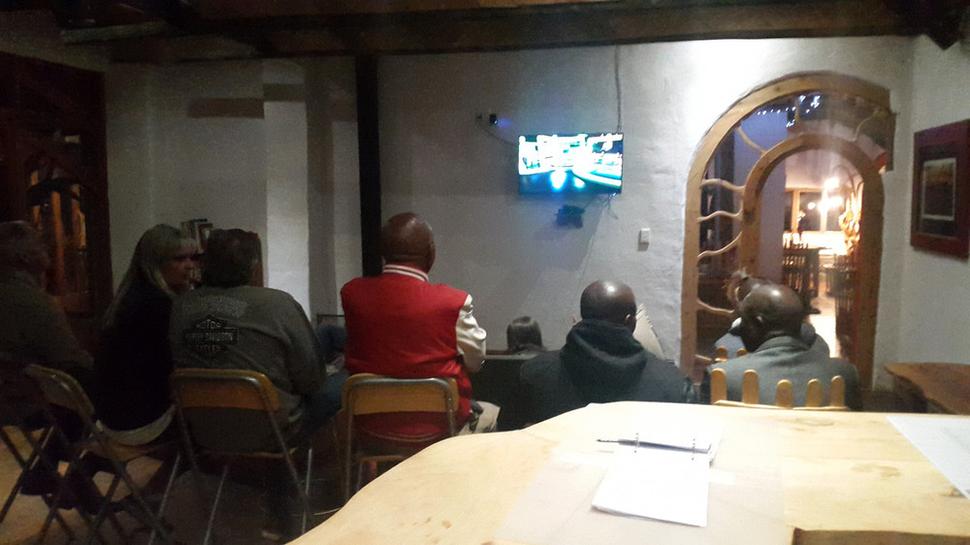 Chlapi pozerajúci rugby počas svadobnej hostiny