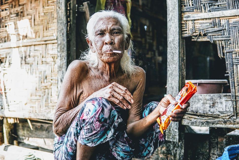 Návšteva miestnej dediny. Sprievodca dáva miestnej žene cigaretu. Dychtivo si ju zapaluje a dodáva, že fajčenie nie je zdravé.