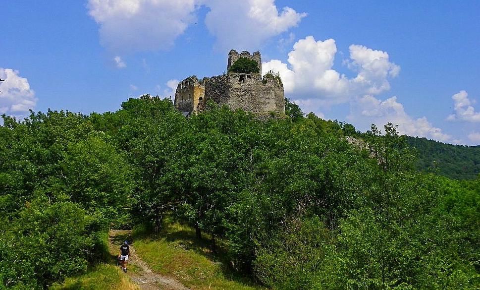 Pohľad na hrad Čabraď od juhu. Riečka Litava obteká z troch strán zrúcaninu kedysi mohutného hradu. Pevnosť Čabraď bola postavená v 13. storočí na ochranu ciest vedúcich k stredoslovenským banským mestám. Pôvodne sa hrad volal Litavským hradom.