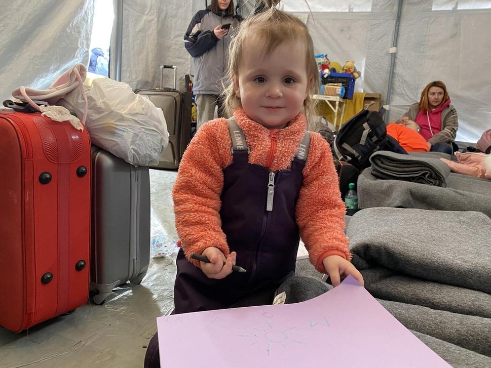 Sofiya si kreslí na papier v UNICEF Modrom bode v Poľsku v blízkosti hranice s Ukrajinou
