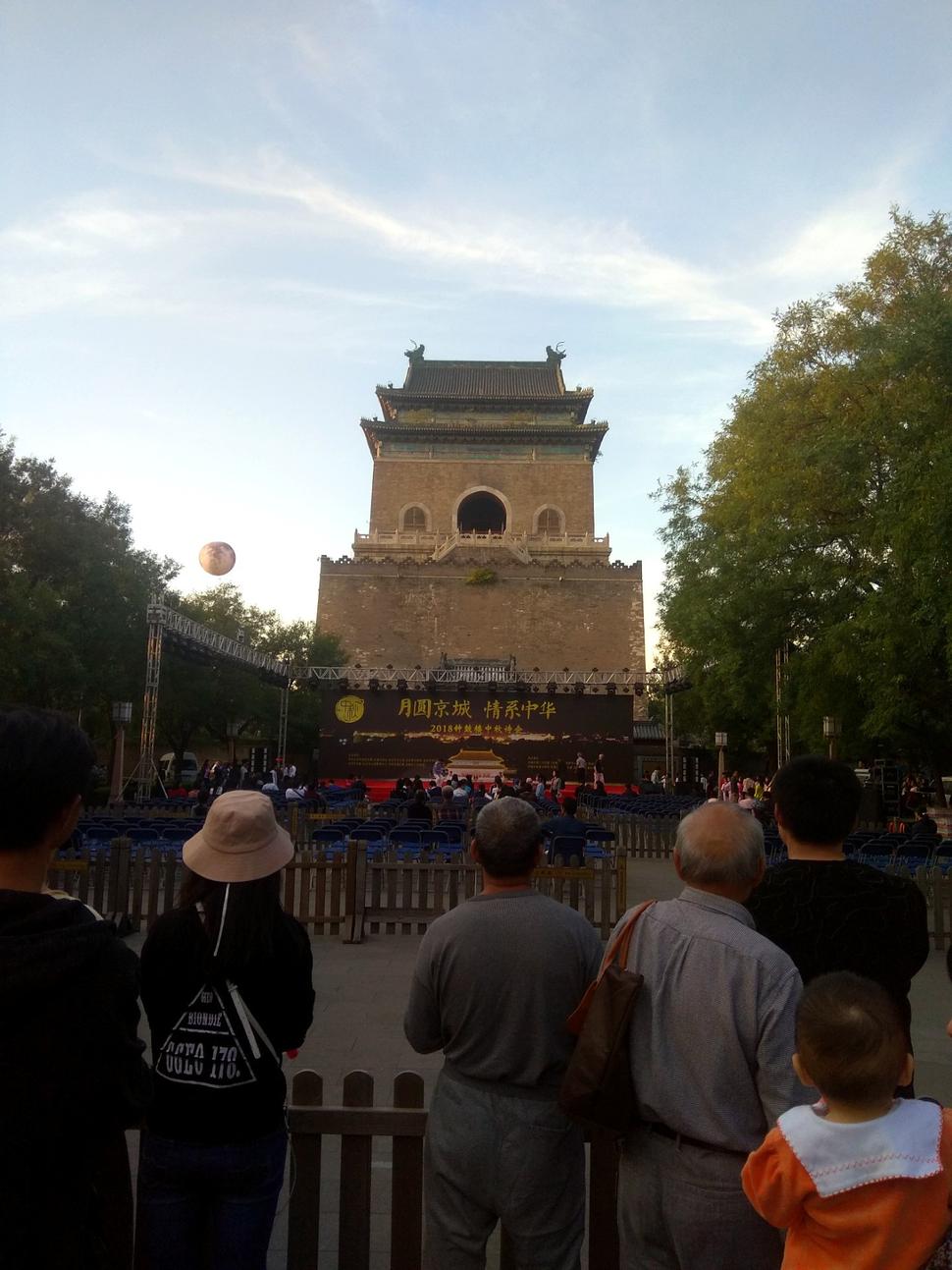Preklad znakov na plagáte: 月圆京城 情系中华 Hlavné mesto v splne, milujme Čínu. Mesiac v pozadí je nafukovací balón. Áno, čakala som niečo kreatívnejšie.
