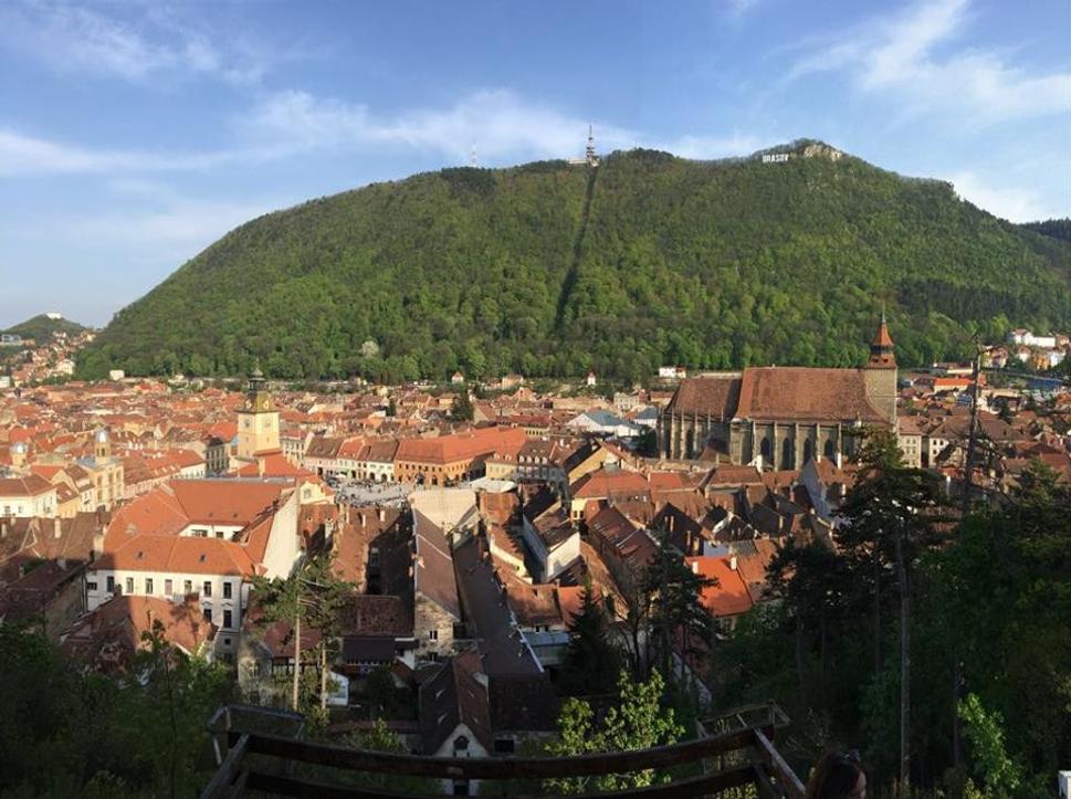 Pohľad na druhé najväčšie mesto Rumunska Brašov. Vľavo radnica, vpravo gotický „čierny kostol.“ Nad mestom sa týči na kopci nápis BRASOV. Dostať k nemu sa dá lanovkou.